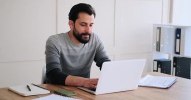 Ofiste dizüstü bilgisayarda daktilo kullanan bir işadamı.