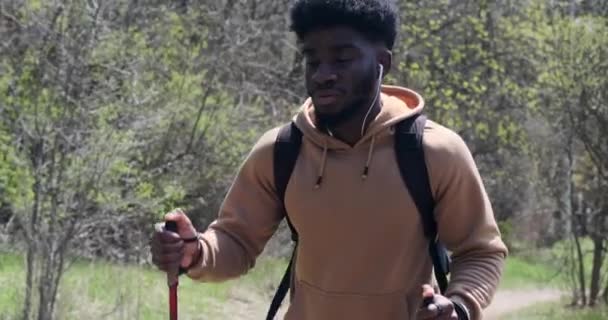 Uomo afroamericano che cammina con bastoni da trekking — Video Stock