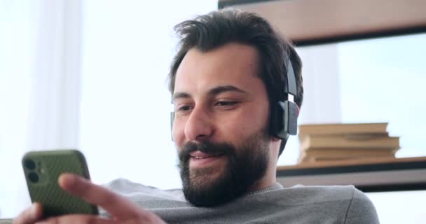 Homem usando telefone celular e ouvir música em fones de ouvido — Vídeo de Stock