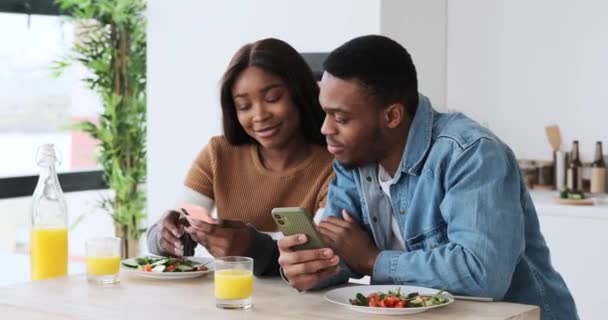 아프리카 계 미국인 부부가 점심을 먹으면서 휴대 전화로 이야기하는 모습 — 비디오