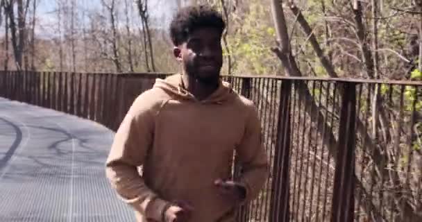 Afrikai amerikai férfi kocog a hídon — Stock videók