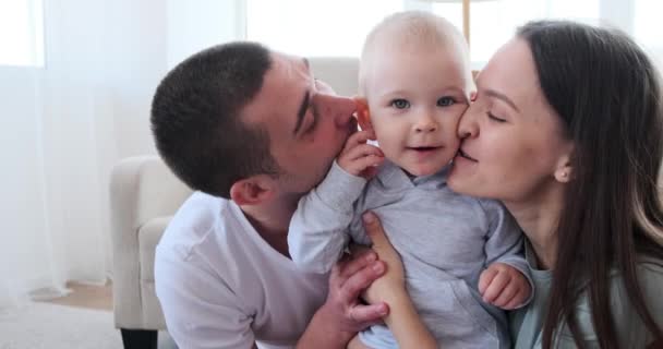 Eltern umarmen und küssen niedlichen Jungen — Stockvideo