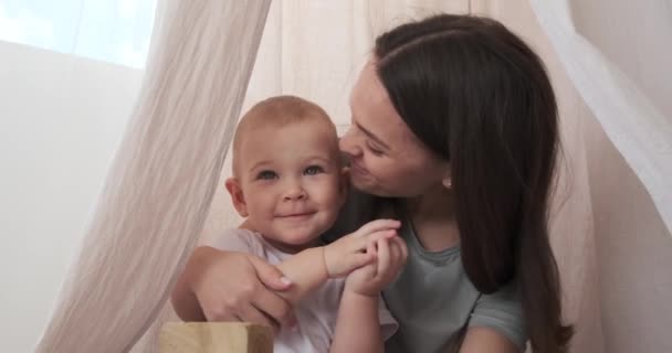 Ibu mencium anak kecil yang lucu di rumah. — Stok Video