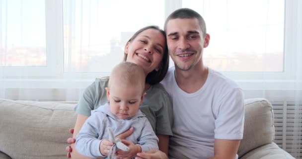 Счастливая семья, сидящая дома на диване — стоковое видео