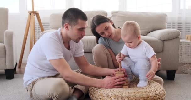 Ouders met baby zoon spelen met behulp van speelgoed blokken — Stockvideo