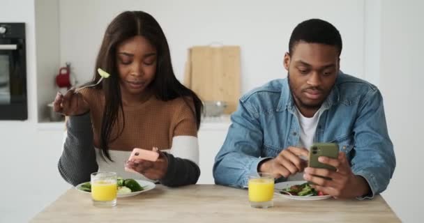 Africký americký pár pomocí mobilního telefonu při obědě — Stock video