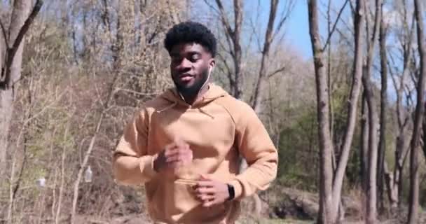 African American man listening music on earphones while running — Stock Video