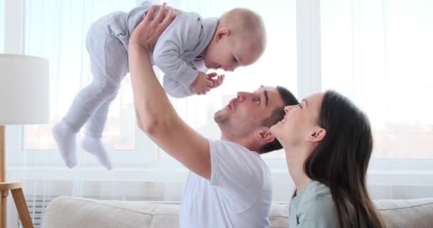 女とともにお父さん持ち上げ遊び心のある赤ちゃん息子で空気 — ストック動画