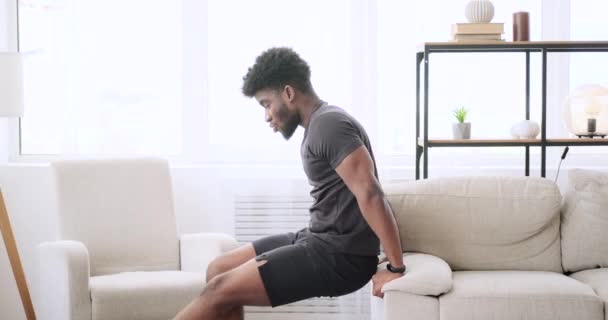 Афроамериканец делает упражнения трицепса на диване — стоковое видео