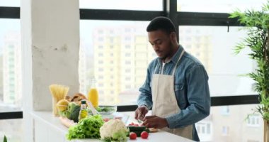 Adam mutfakta taze domates kesiyor.