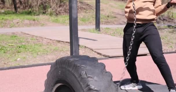 Hombre golpeando neumático con martillo mientras hace ejercicio — Vídeos de Stock