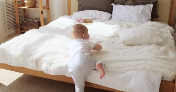 Mały chłopiec bawiący się w domu w łóżku — Wideo stockowe