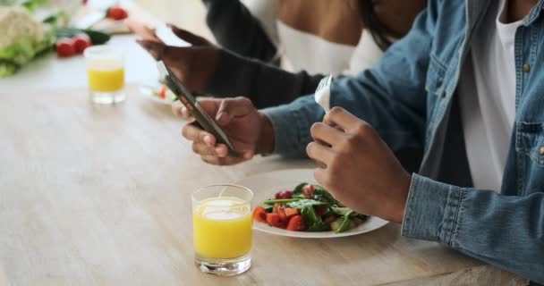 Ζευγάρι μηνυμάτων κειμένου χρησιμοποιώντας το κινητό τηλέφωνο, ενώ έχοντας το μεσημεριανό γεύμα — Αρχείο Βίντεο