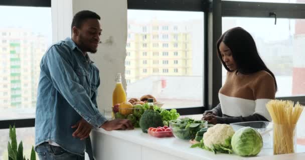 Couple préparer la nourriture et discuter dans la cuisine — Video