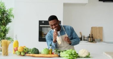 Salatayı kasede hazırlarken şarkı söyleyen ve dans eden adam