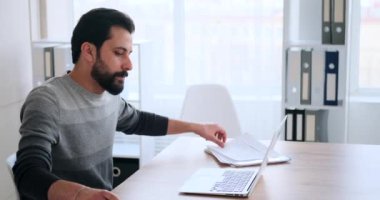 İş adamı not yazıyor ve laptop kullanıyor