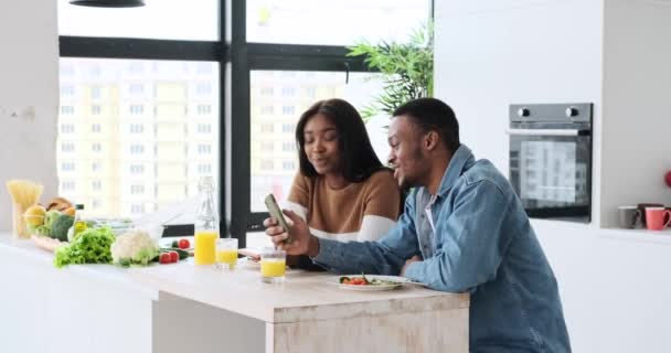 Pasangan yang menunjukkan dan mendiskusikan melalui telepon genggam saat makan siang — Stok Video