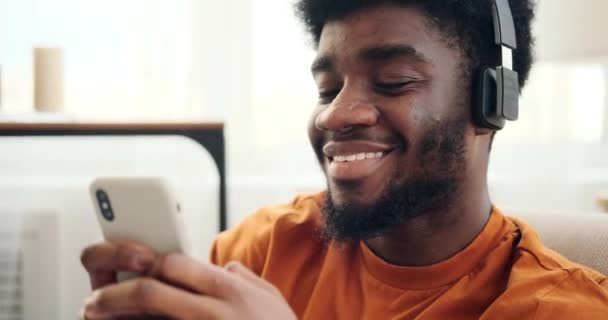 Man using mobile phone while listening music on headphones — Stock Video