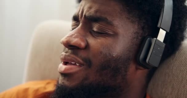 Homem ouvindo música em fones de ouvido e relaxando na poltrona — Vídeo de Stock