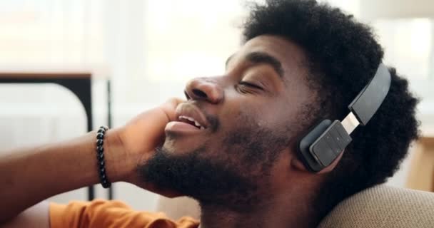 Homem ouvindo música em fones de ouvido e inclinando-se na poltrona — Vídeo de Stock