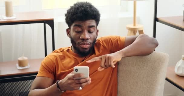 Mann lehnt sich auf Sessel und benutzt Handy — Stockvideo