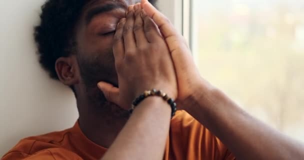 Trauriger junger Mann schaut aus Fenster — Stockvideo