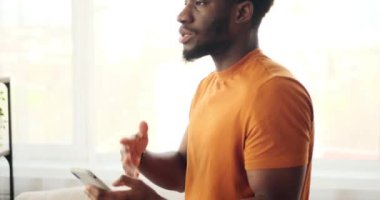 Afrikalı Amerikalı adam cep telefonuyla görüntülü konuşma yapıyor.