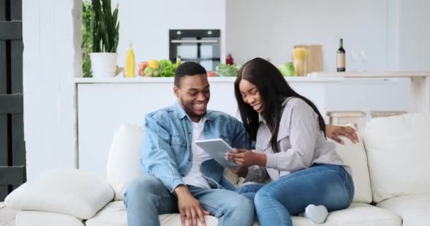 Pareja afroamericana riendo y usando tableta digital — Vídeo de stock