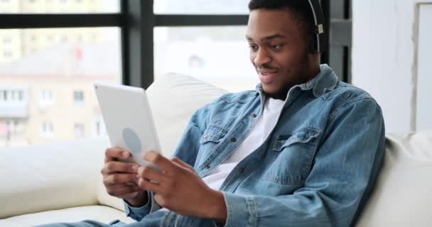 Hombre en auriculares jugando juego en la tableta digital — Vídeo de stock