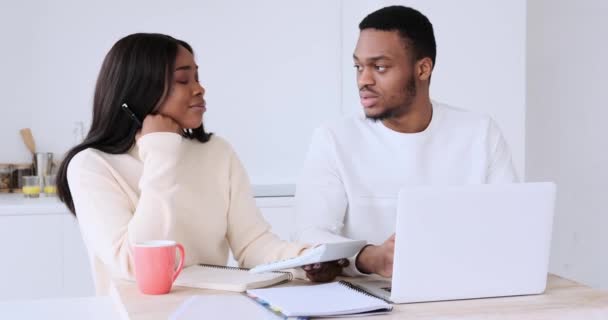 Man werkt aan laptop bespreken met vrouw met behulp van rekenmachine — Stockvideo