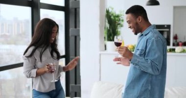 Evde şarap içip dans eden bir çift.