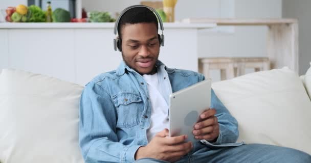 Mann mit Kopfhörer spielt Spiel auf digitalem Tablet — Stockvideo