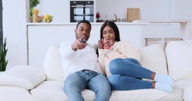 Mutlu çift evde televizyon izliyor.