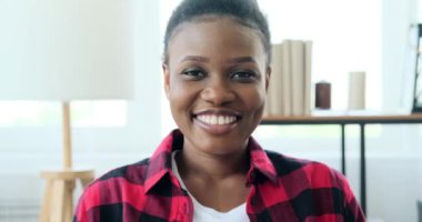 Evde gülümseyen mutlu genç kadın.