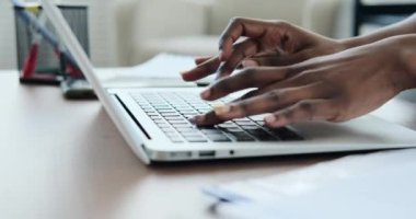Dizüstü bilgisayarda yazarken telefona bakan kadın
