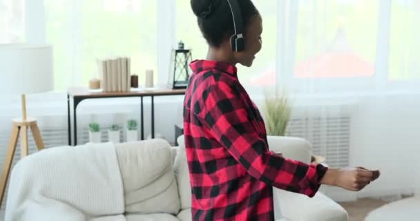 Vrouw dansen tijdens het luisteren muziek op de hoofdtelefoon — Stockvideo