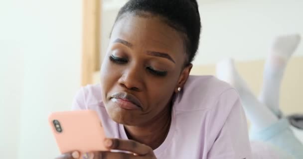 Femme heureuse utilisant le téléphone mobile sur le lit — Video