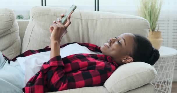 Nő fekszik a kanapén, és a mobiltelefon — Stock videók