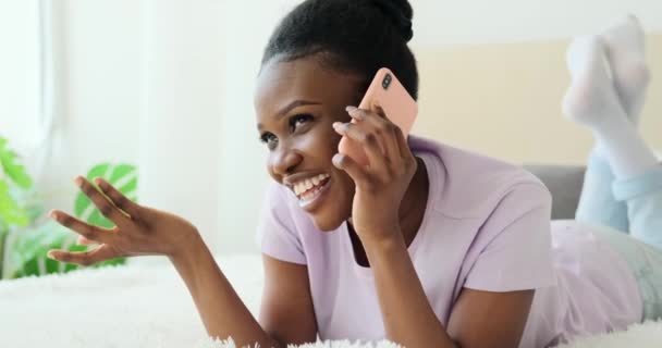 Afro-Amerikaanse vrouw praten op mobiele telefoon liggend op bed — Stockvideo