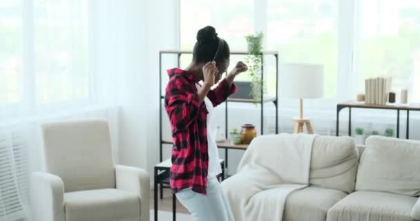 Junge Frau tanzt, während sie Musik über Kopfhörer hört — Stockvideo