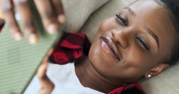 Africká americká žena ležící na pohovce a pomocí mobilního telefonu — Stock video
