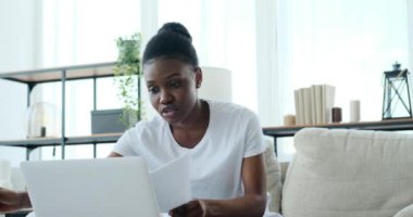 Kadın video konferansı dizüstü bilgisayar kullanarak ve belgeleri analiz ederek