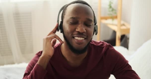 Мужчина слушает музыку в наушниках дома — стоковое видео