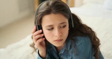 Kulaklıkla müzik dinleyen düşünceli bir kadın.