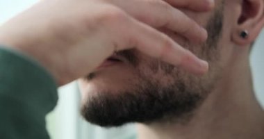 Depresyondaki genç adam pencereden dışarı bakıyor.