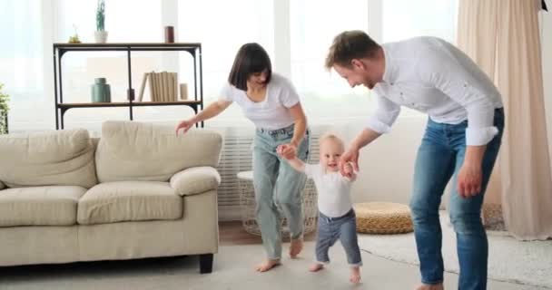 Pais ajudando o bebê filho a andar — Vídeo de Stock