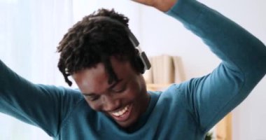 Kulaklıkla müzik dinleyen ve dans eden bir adam