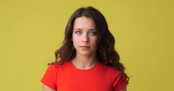 Serious woman in thoughts over yellow background — Stock Video