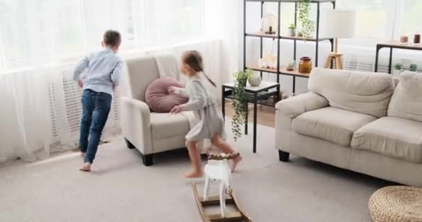 Kinderen spelen tag game in de woonkamer — Stockvideo
