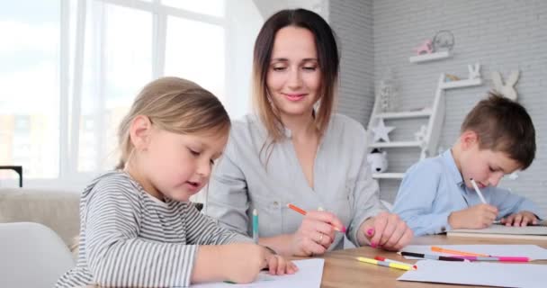 Anne çocuklara ödevlerinde yardım ediyor. — Stok video